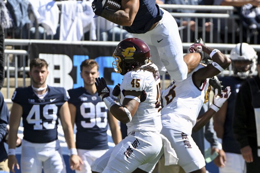 Penn State tight end Brenton Strange (86) hurdles Central Michigan defenders Lavario Wiley (6) and Justin Whiteside (45) during the first half of an NCAA college football game, Saturday, Sept. 24, 2022, in State College, Pa. (AP Photo/Barry Reeger)