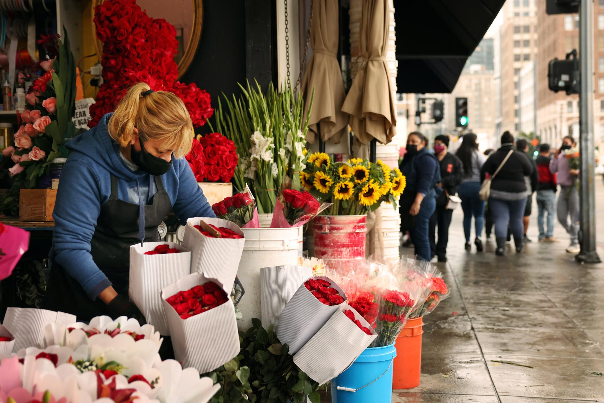 Adriana Gamez restocks the rose bouquets for sale at California Flowers in downtown L.A. on Friday.