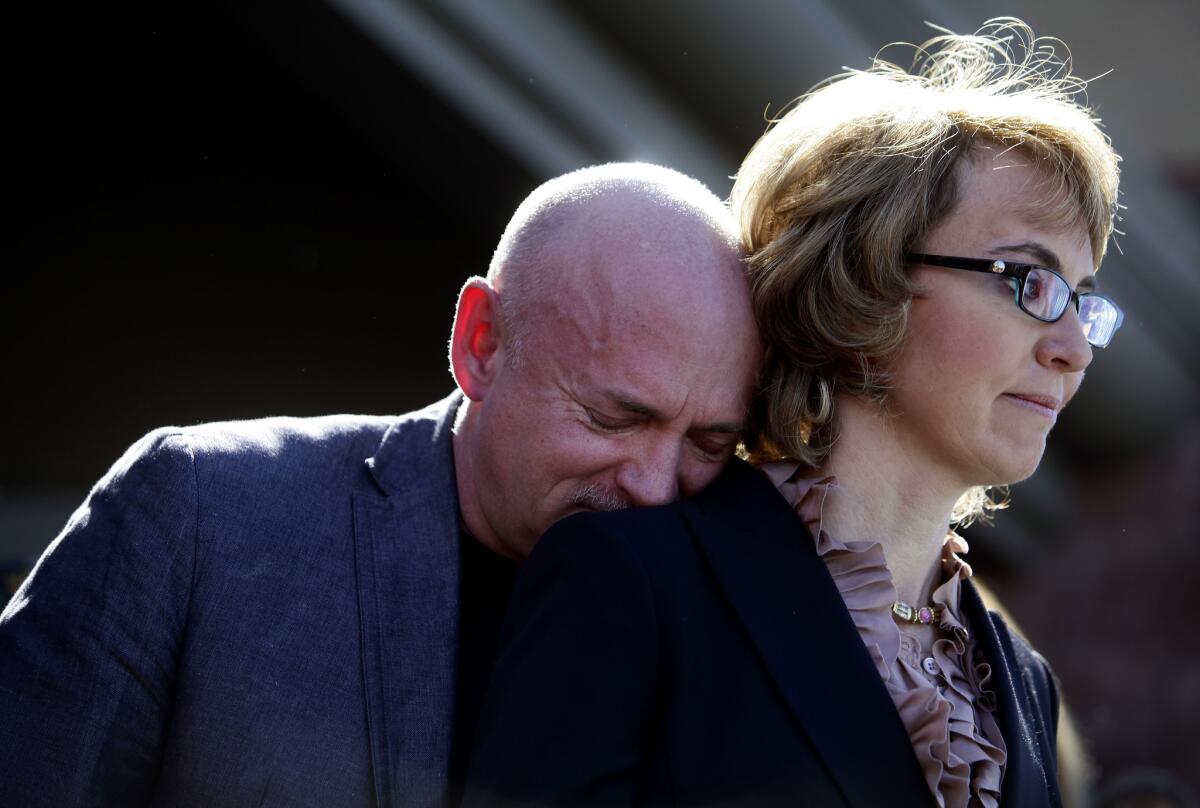 Mark Kelly leans his head on the shoulder of his wife and former U.S. Rep. Gabby Giffords as they attended a news conference last March asking Congress to pass stricter gun controls.