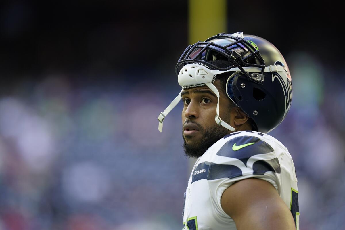 Seattle Seahawks linebacker Bobby Wagner has his helmet pushed above his eyes as he looks across the field.