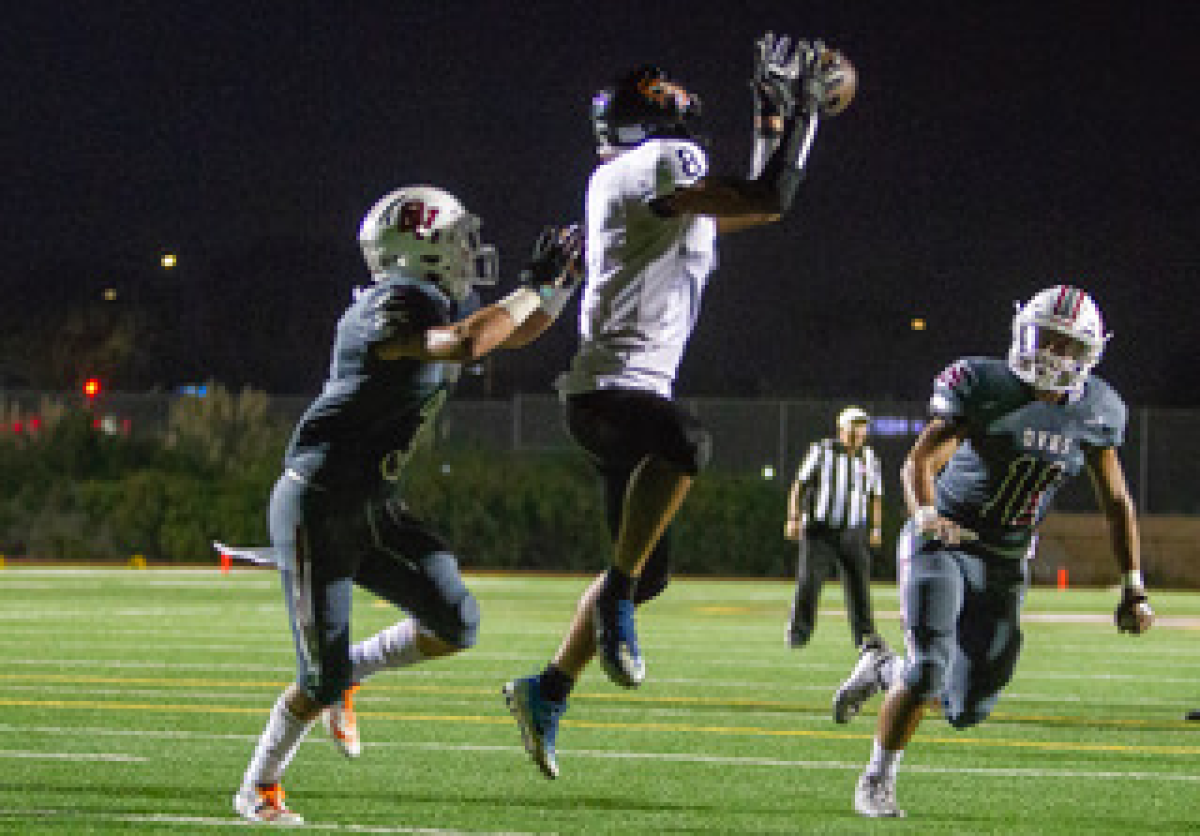 Los Amigos' Juan Contreras goes up to catch a 10-yard touchdown against Ocean View's Anthony Ramirez in a nonleague game on Friday in Huntington Beach.