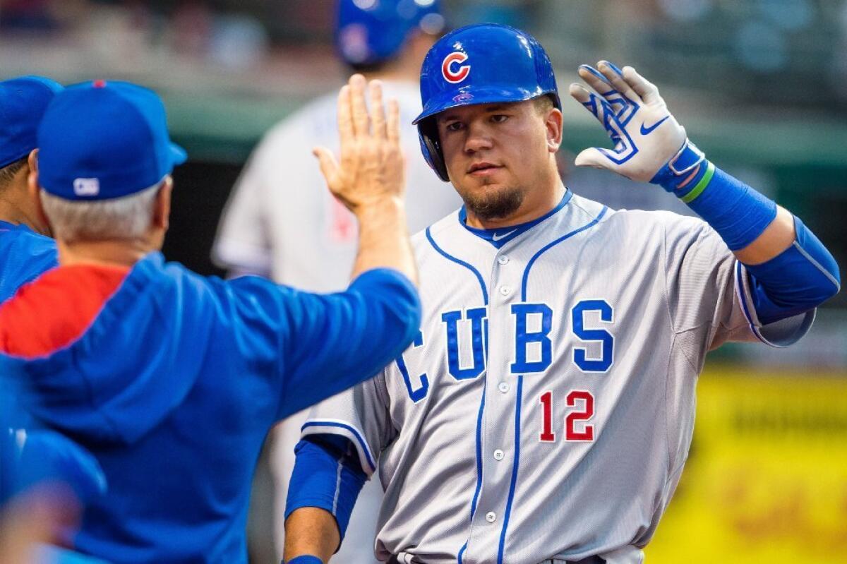 Cubs rookie Kyle Schwarber gets a high-five from Manager Joe Maddon after scoring against the Indians on June 18.