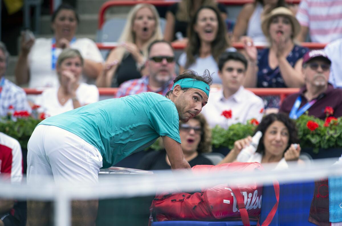 Rafael Nadal of Spain falls over the bench in his match against Daniel Evans of Britain during the Rogers Cup mens tennis tournament Wednesday, Aug. 7, 2019, in Montreal. (Paul Chiasson/The Canadian Press via AP)