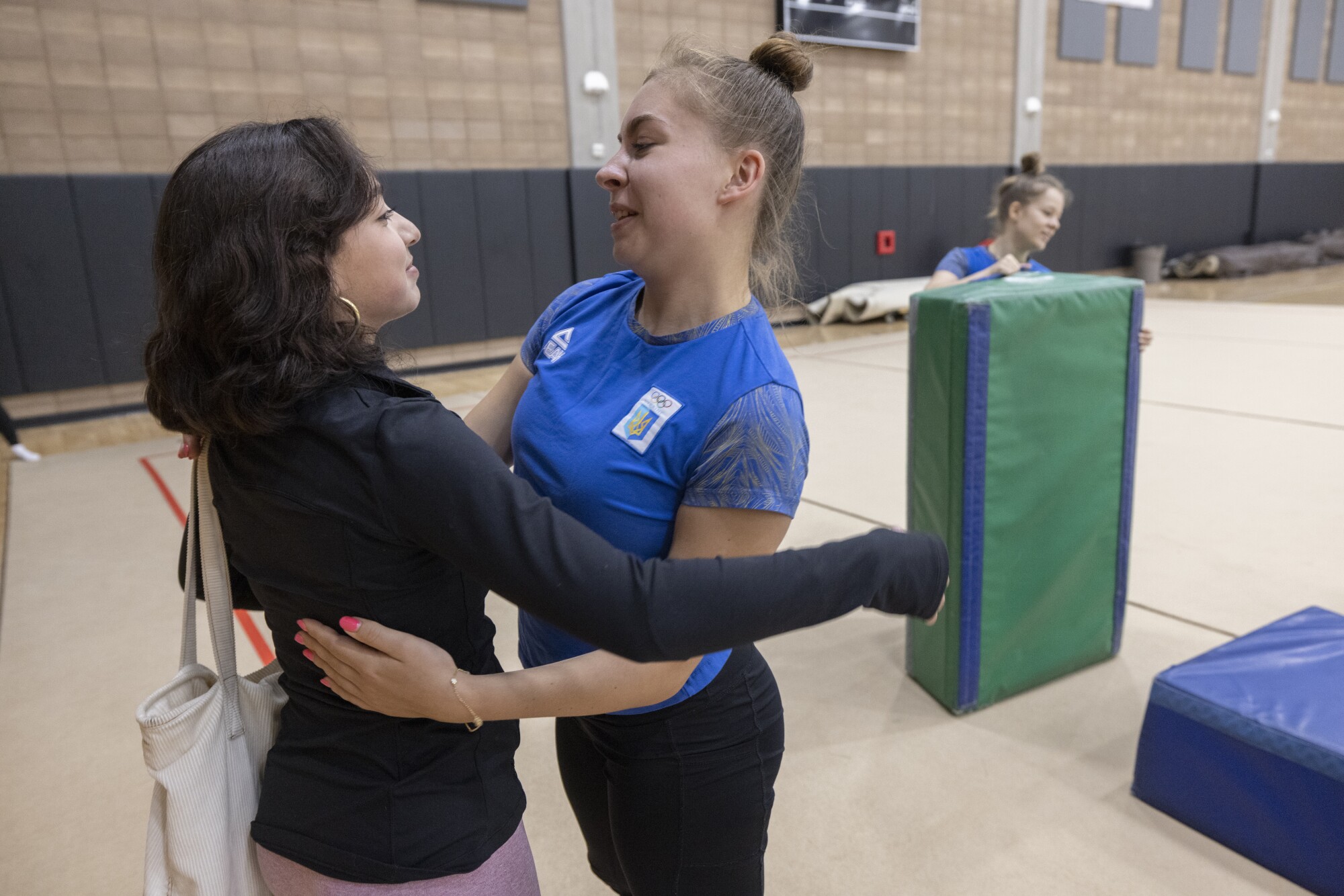 Alina Salmanova, 20, right, hugs Fernanda Gutierrez, coach of Team Emerald, during practice