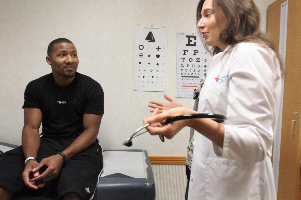 Aaron Hodges sees nurse practitioner Gina Quigley at a CVS Minute Clinic in Los Angeles. In a survey, employers see health-benefit costs rising 5% in 2015.