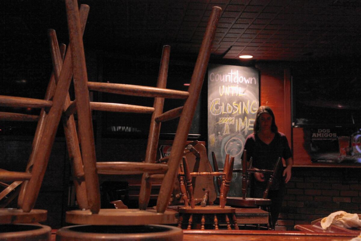 An O'Hara's employee stacks stools in front of a chalkboard that reads "0 days to closing time," a reference to the bar's traditional last call song, "Closing Time" by Semisonic.