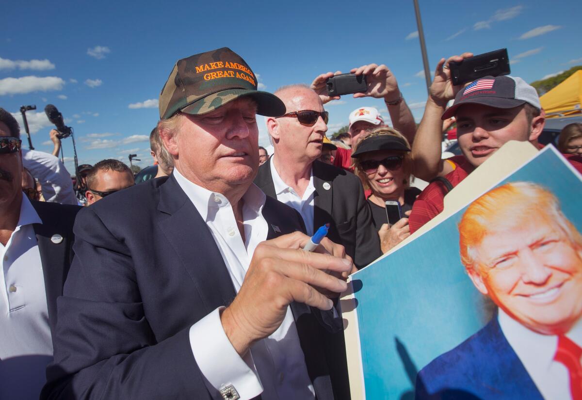 In Ames, Iowa, on Saturday, GOP presidential candidate Donald Trump greets fans before the start of the Iowa State University versus University of Iowa football game on Saturday.
