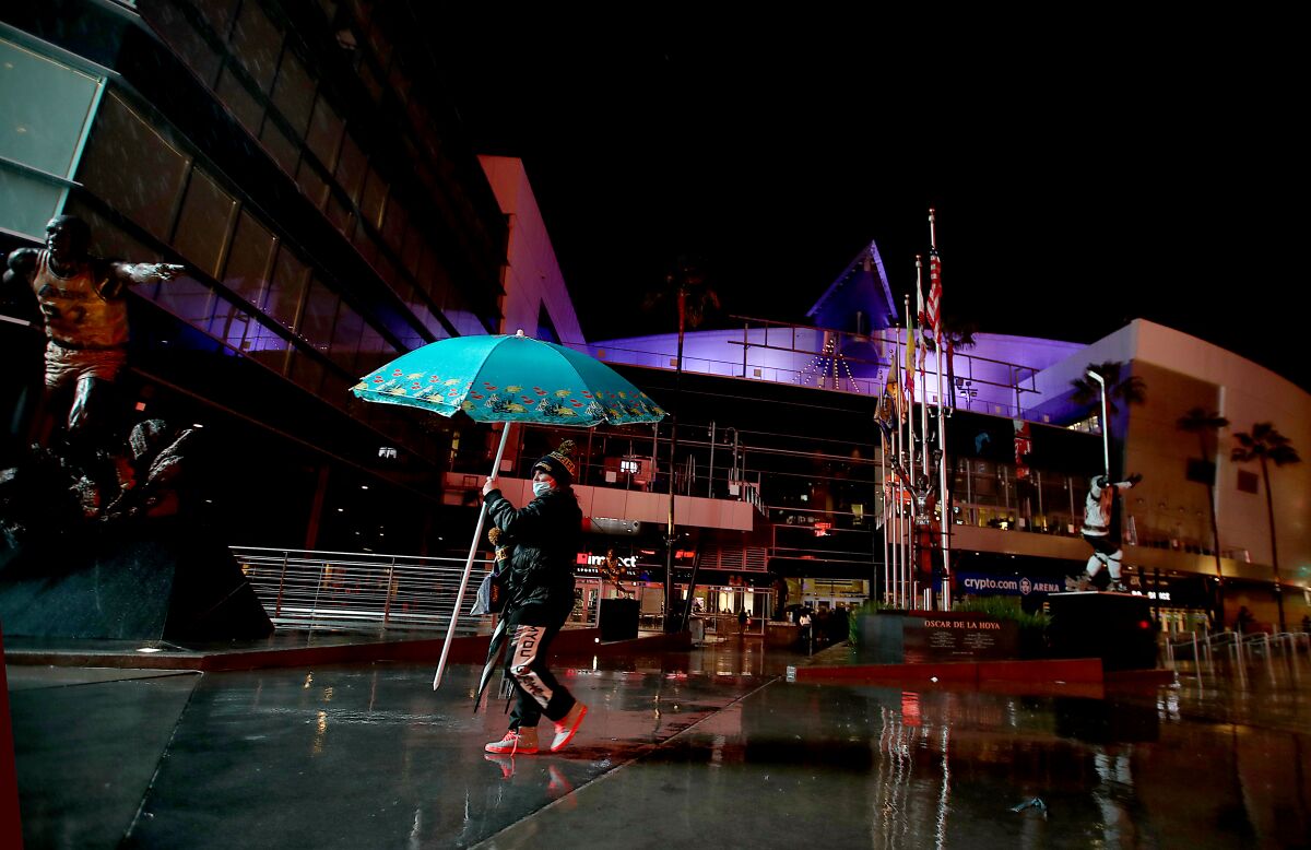 A street vendor peddles umbrellas on a rainy Thurday night in downtown Los Angeles.
