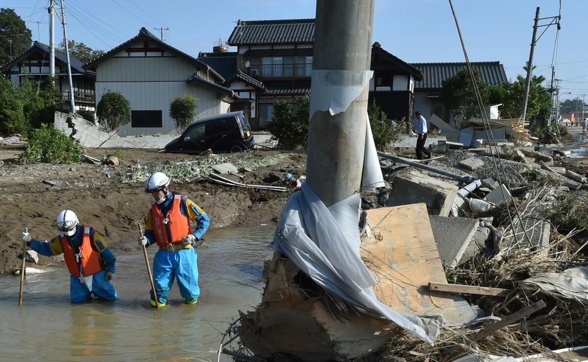 Police wade through water as they provide assistance Saturday following Thursday's flooding in Joso City, Japan.