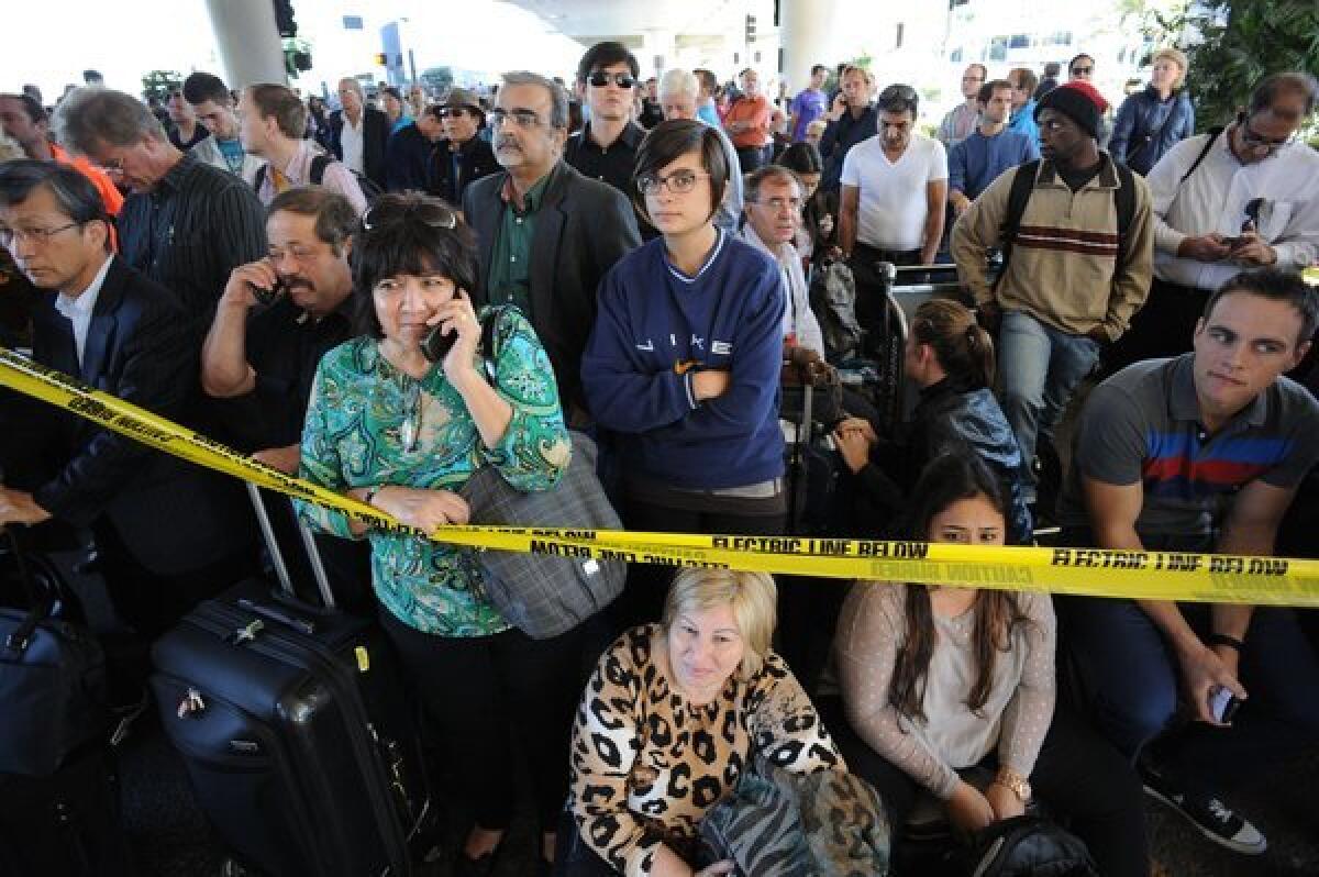 Passengers whose flight to China was canceled gather outside the airport after a shooting at Los Angeles International Airport on Nov. 1.
