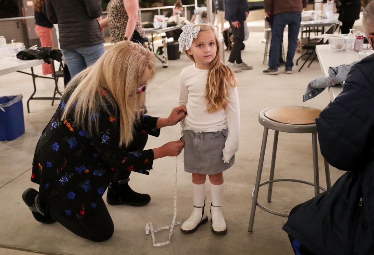 Volunteer Kathleen Pondinas, left, measures Layla Hartwell-Lewis during casting calls for the Pageant of the Masters.