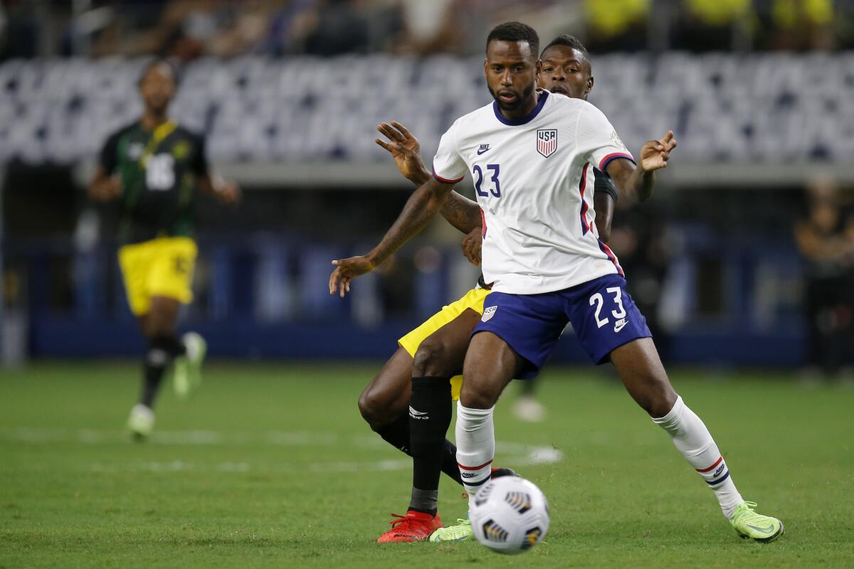 United States midfielder Kellyn Acosta attempts to gain control of the ball in front of Jamaica forward Cory Burke.