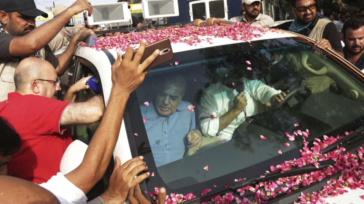 Shahbaz Sharif, in car at left, leaves for the airport in Lahore, Pakistan, on July 13, 2018.