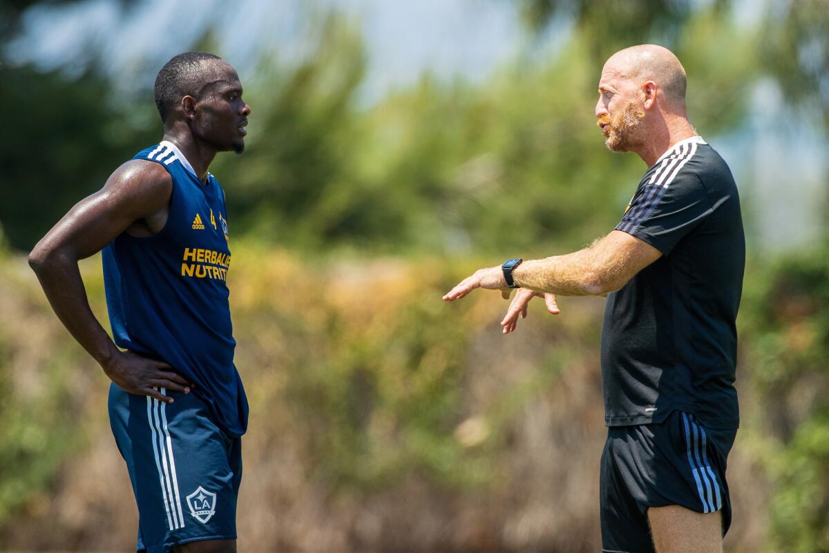 The Galaxy's Séga Coulibaly, left, talks with Dan Calichman during training