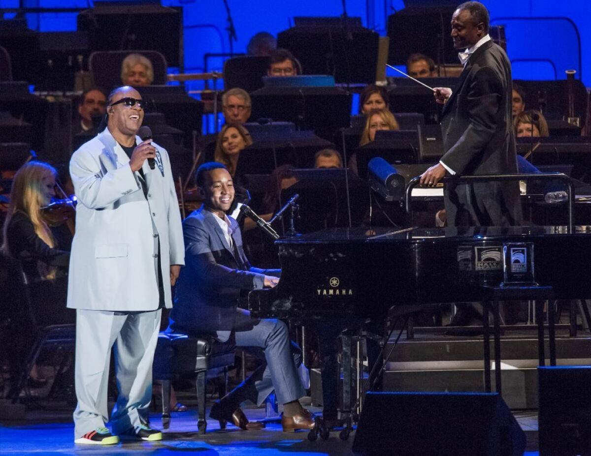 Stevie Wonder, left, and John Legend perform at the Hollywood Bowl, backed by the Hollywood Bowl Orchestra under the baton of Thomas Wilkins.