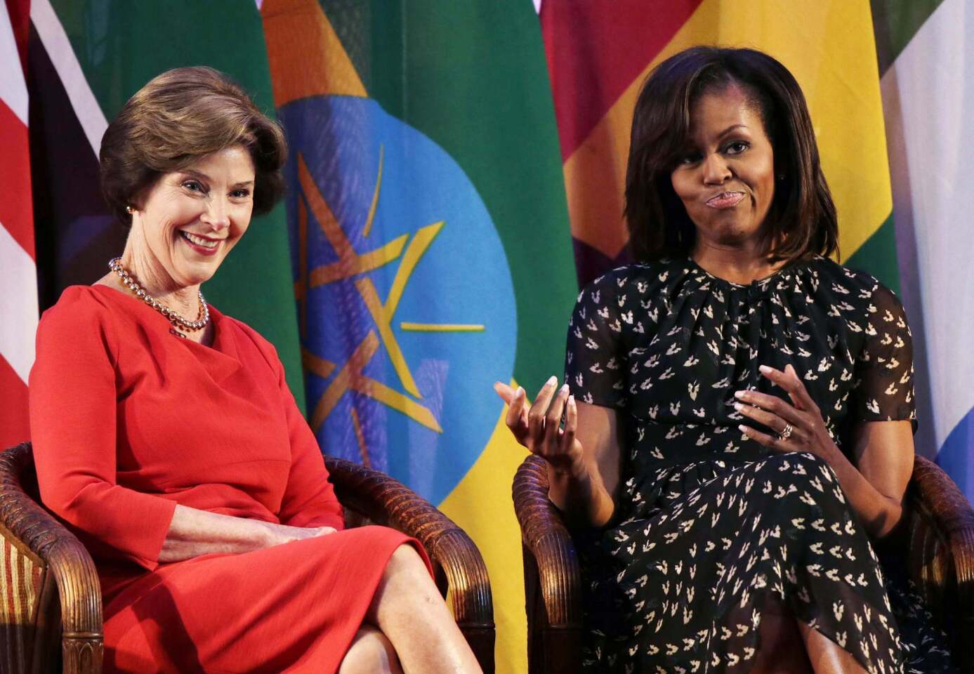 Former U.S. First Lady Laura Bush smiles next to current U.S. First Lady Michelle Obama at the African First Ladies Summit in Dar Es Salaam