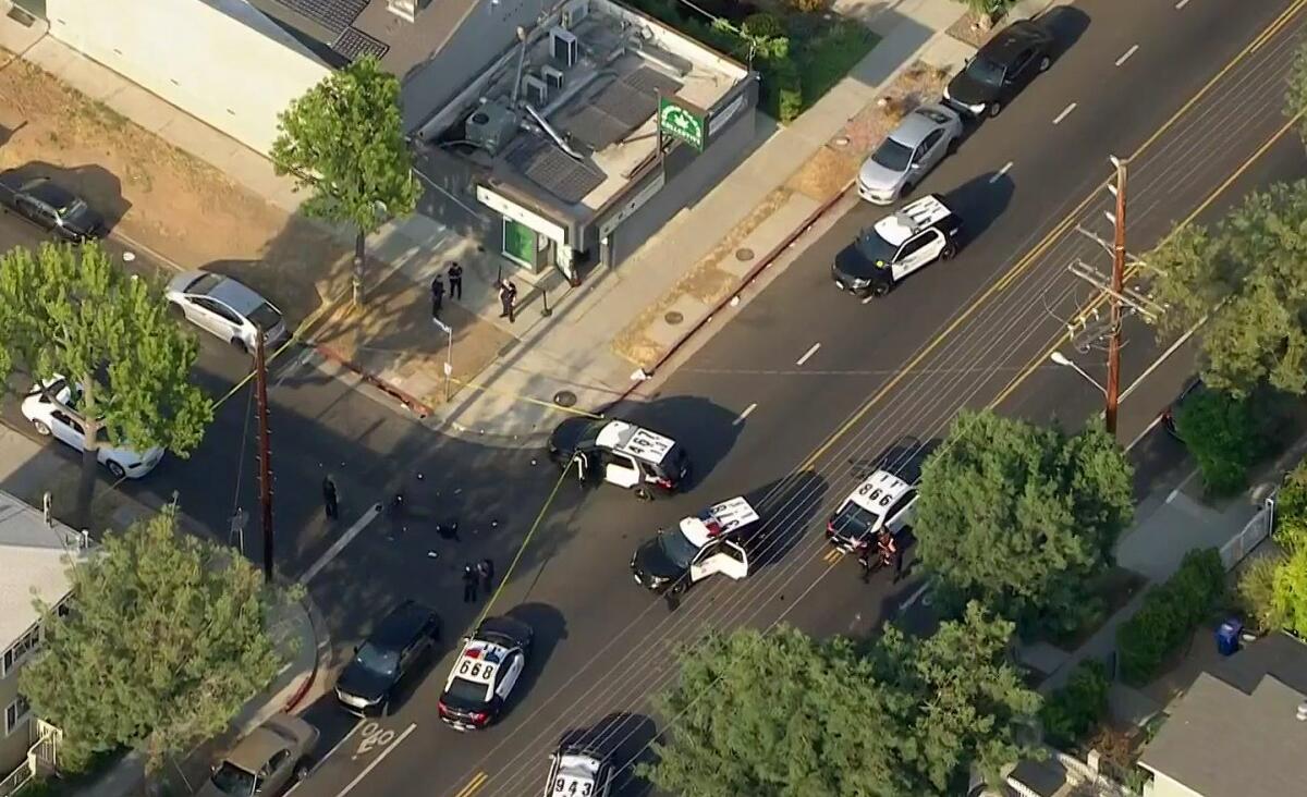 An aerial view shows several police cars in the street