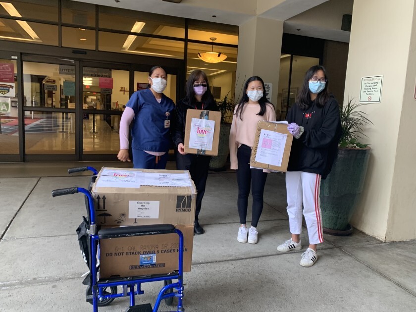 Ruby Gao, right and Katherine Ge, second to right, donated surgical masks to Alvarado Hospital through their Project Butterfly.