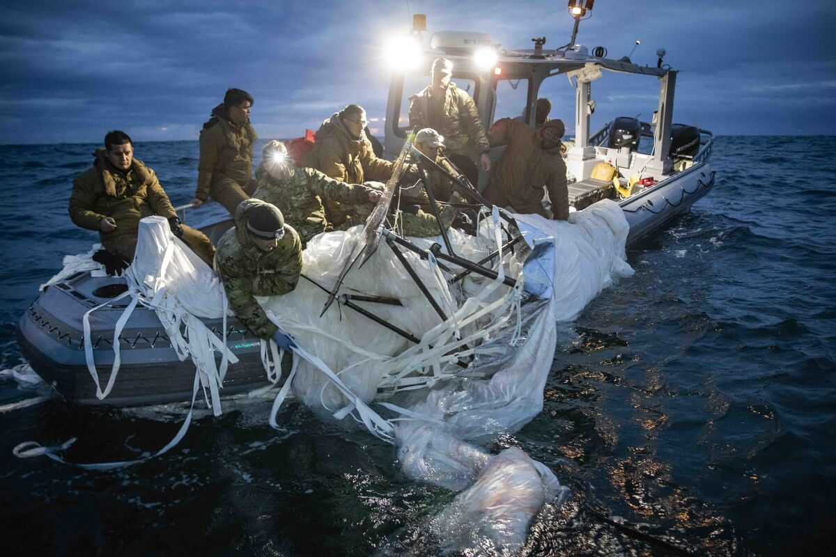This image provided by the U.S. Navy shows sailors assigned to Explosive Ordnance Disposal Group 2 recovering a high-altitude surveillance balloon off the coast of Myrtle Beach, S.C., Feb. 5, 2023. (U.S. Navy via AP)
