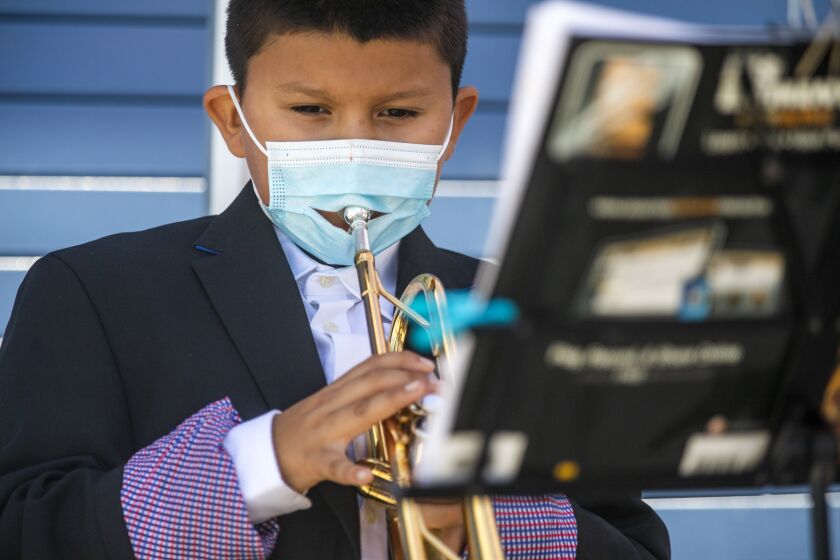 INGLEWOOD, CA - JULY 28: Eddie Munoz, 9, playing the trumpet during a concert at Woodworth-Monroe Middle School on Wednesday, July 28, 2021 in Inglewood, CA. Several groups of students performed a concert outdoors wearing facemarks. The Musicians at Play (MAP) Foundation has partnered with Inglewood School District to bring music education back to students during the COVID pandemic. (Francine Orr / Los Angeles Times)