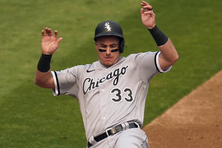 Chicago White Sox's James McCann slides into home to score against the Oakland Athletics.