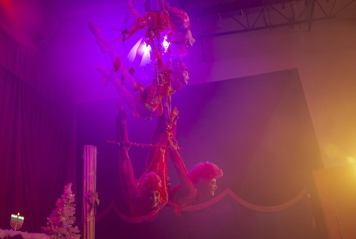 Circus artists perform, in an in-camera double exposure image.