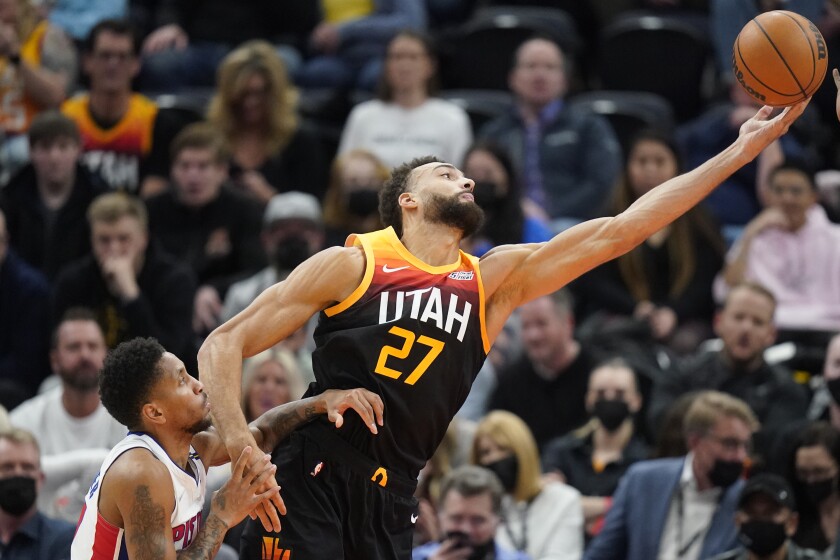 Detroit Pistons guard Rodney McGruder, left, looks on as Utah Jazz center Rudy Gobert (27) reaches for a pass in the first half during an NBA basketball game Friday, Jan. 21, 2022, in Salt Lake City. (AP Photo/Rick Bowmer)