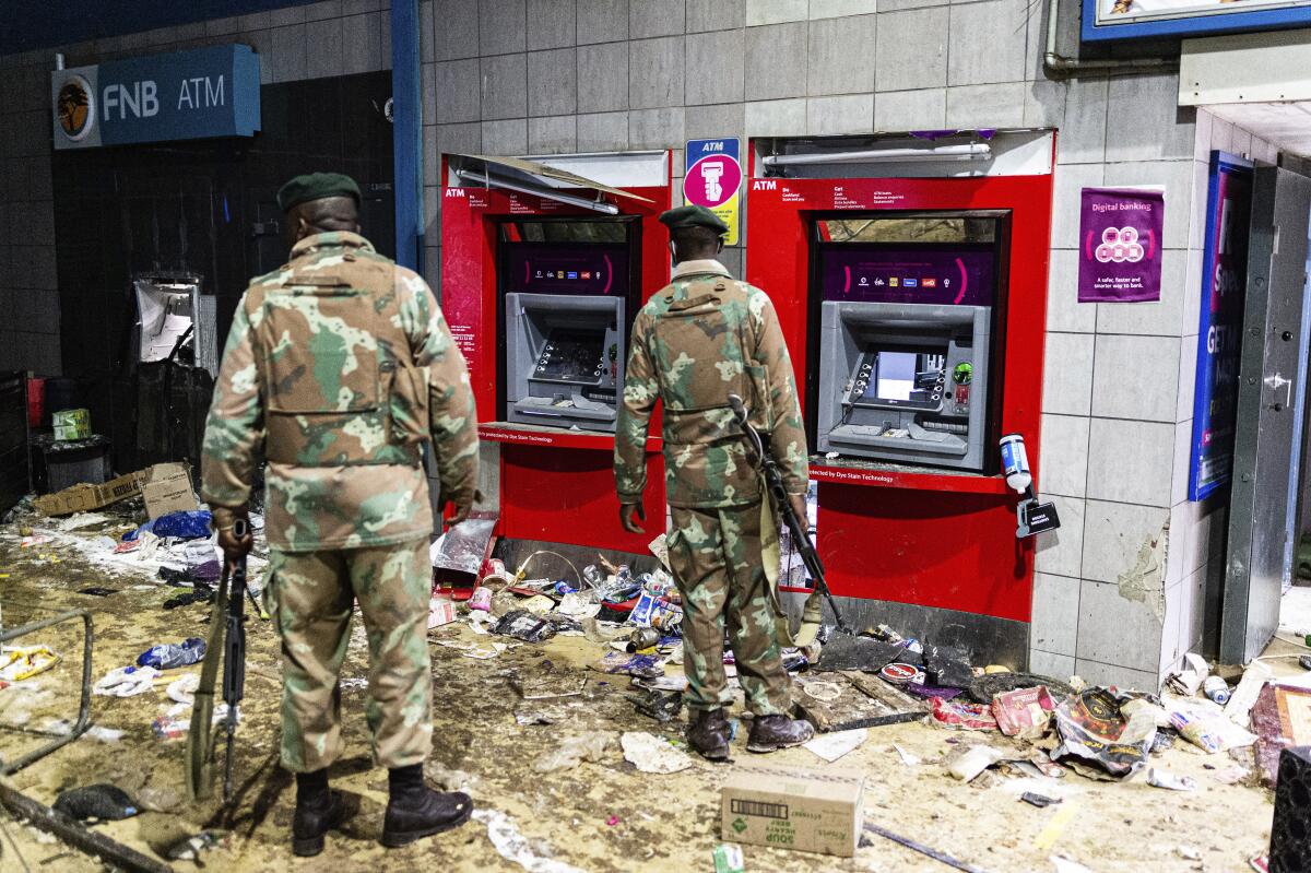 Soldiers in front of a damaged ATM.