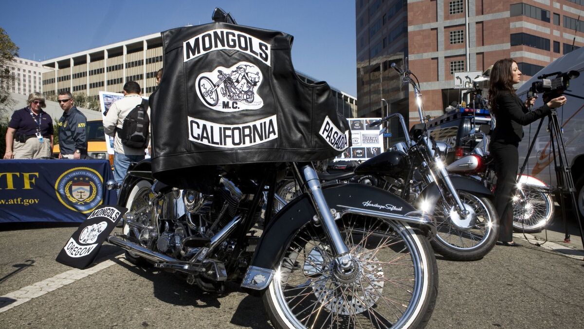 The Mongols motorcycle club logo is seen in the foreground at a news conference in Los Angeles.