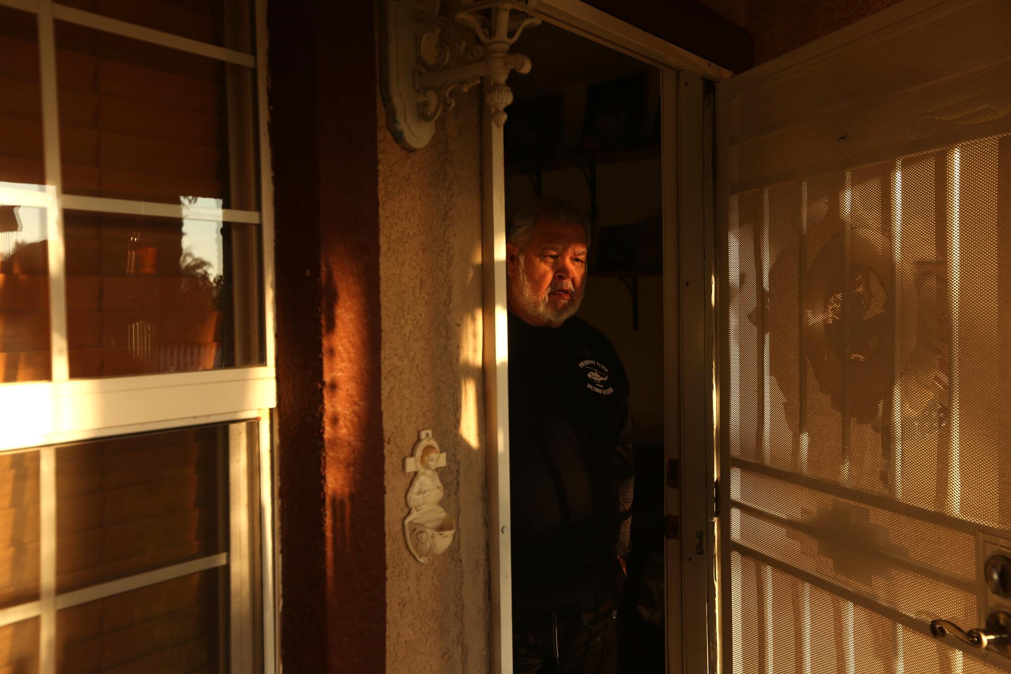 A man at the front door of his home in Planada