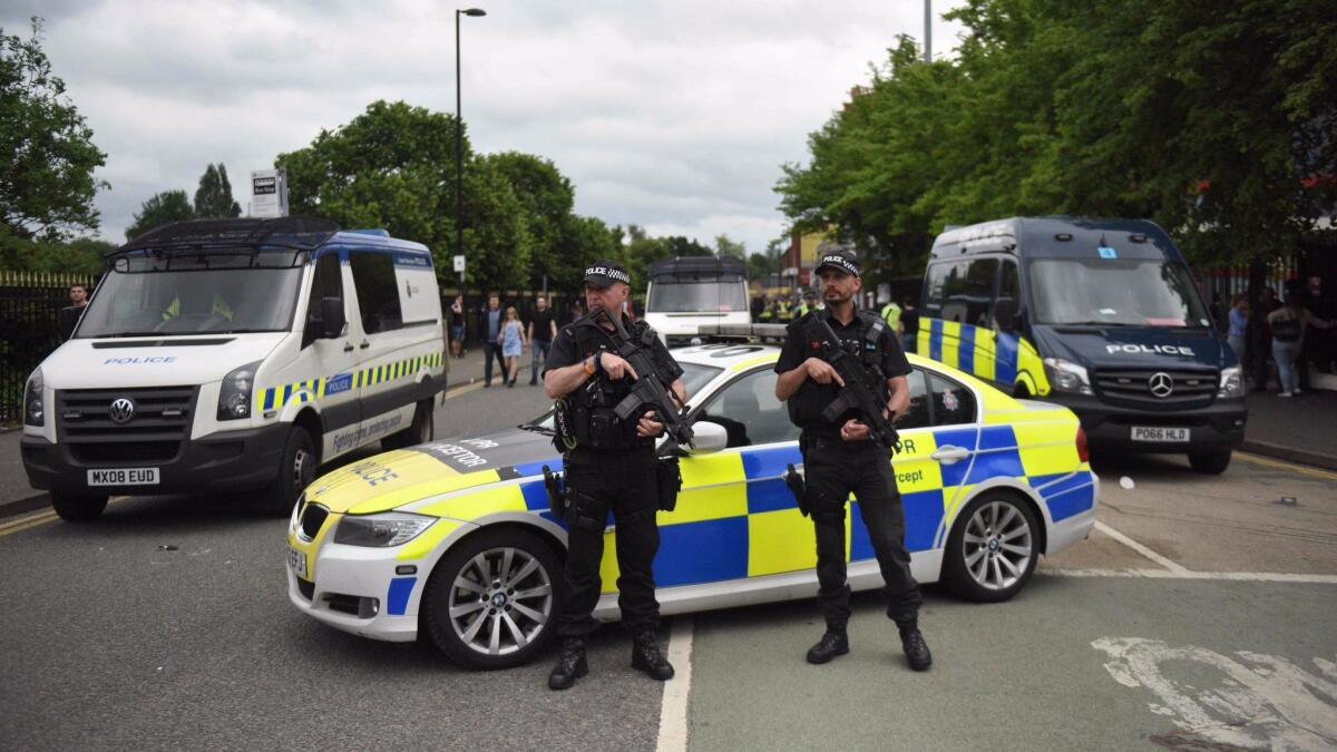 Police officers secure the area as people arrive to attend a concert at the Old Trafford cricket ground in Manchester, England, on May 27.