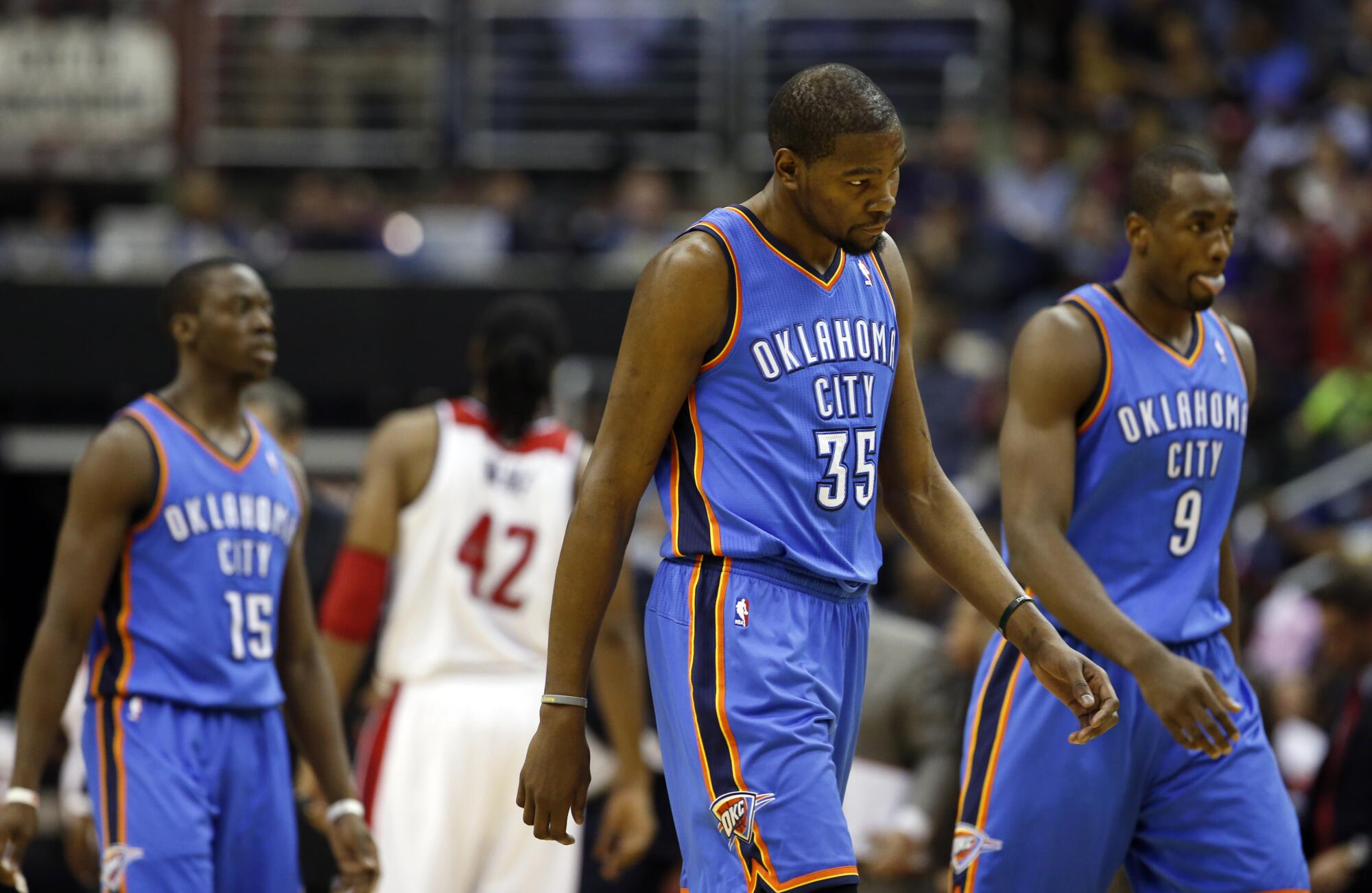 Thunder guard Reggie Jackson, forward Kevin Durant and center Serge Ibaka walk off the court for a timeout in 2014.