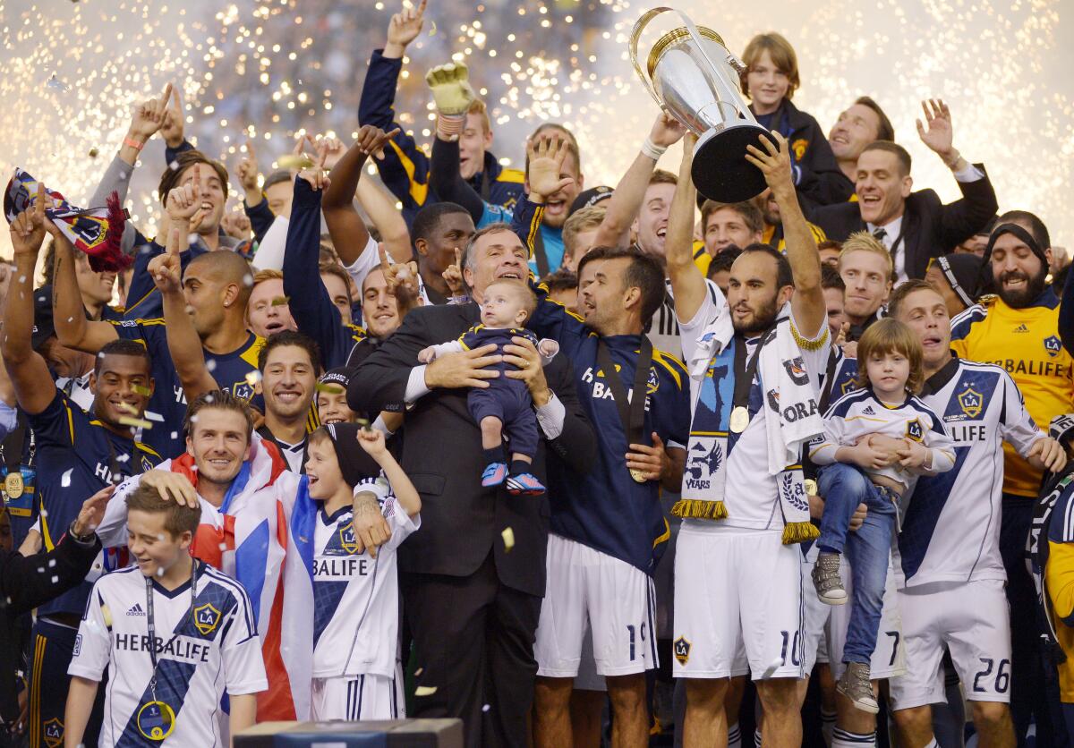 Landon Donovan MLS Kupası'nı tutarken Galaxy antrenörü Bruce Arena, David Beckham ve takım arkadaşları onun yanında kutlama yapıyor
