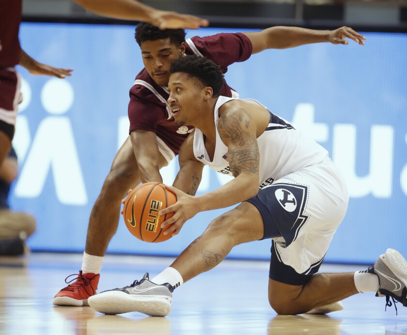 BYU guard Te'Jon Lucas (R) scrambles for the ball with Texas Southern guard PJ Henry (L) during the first half of an NCAA college basketball game Wednesday, Nov. 24 2021, in Provo, Utah. (AP Photo/George Frey)