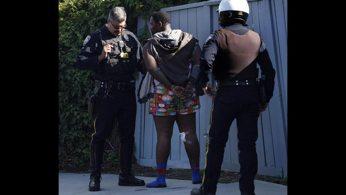 A Beverly Hills police officer talks with one of two people from a car stopped after a high-speed chase in Beverlywood.