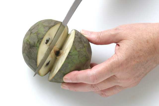 Step 1: Cut the cherimoya in half, then into quarters.