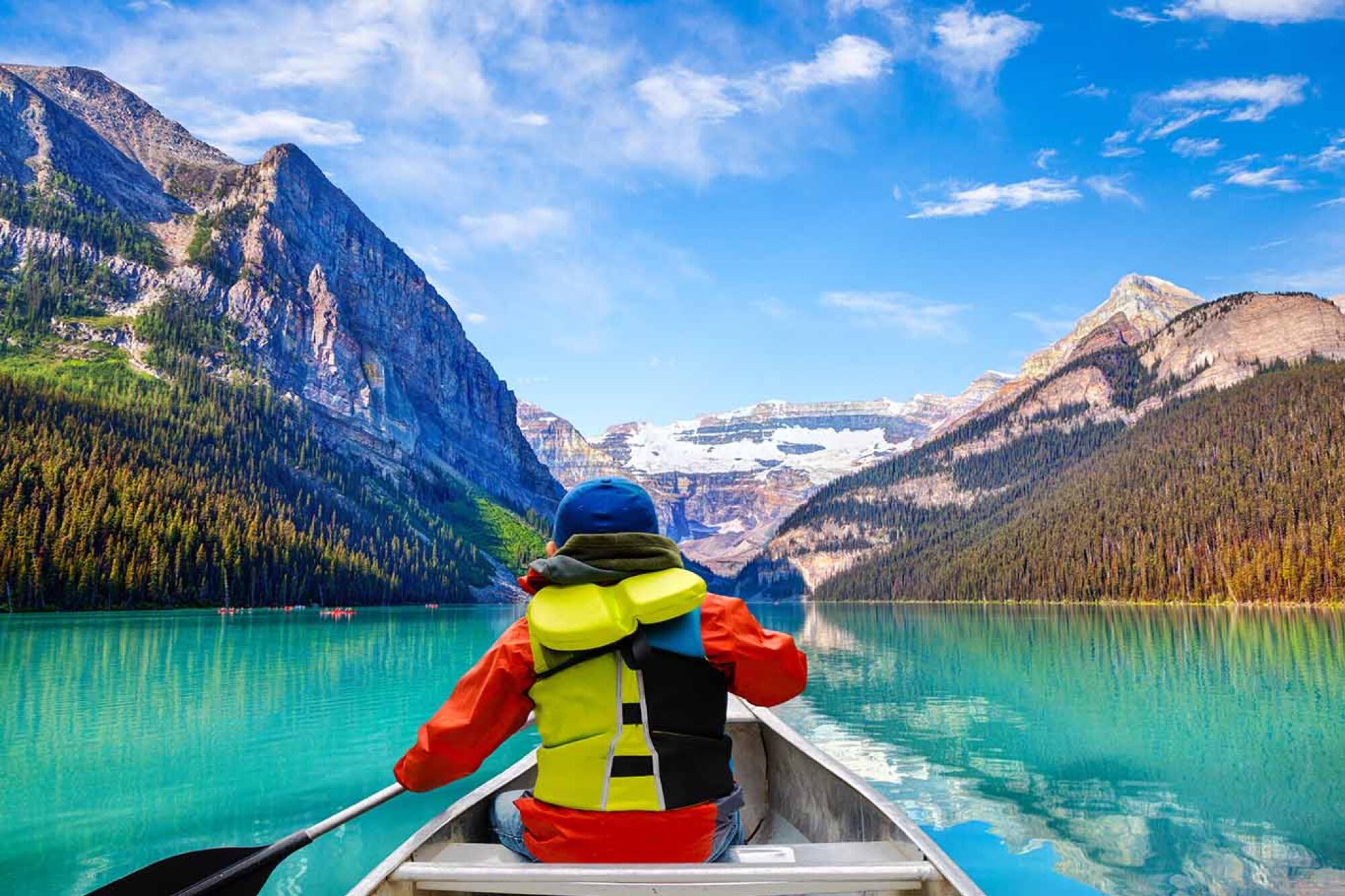 Canoeing on Lake Louise in Banff National Park with Mount Victoria Glacier in the background.