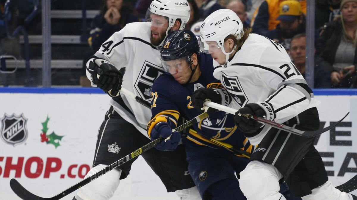 Buffalo Sabres forward Kyle Okposo, center, battles Kings' Derek Forbort, left, and Nikita Scherbak during the third period on Tuesday.