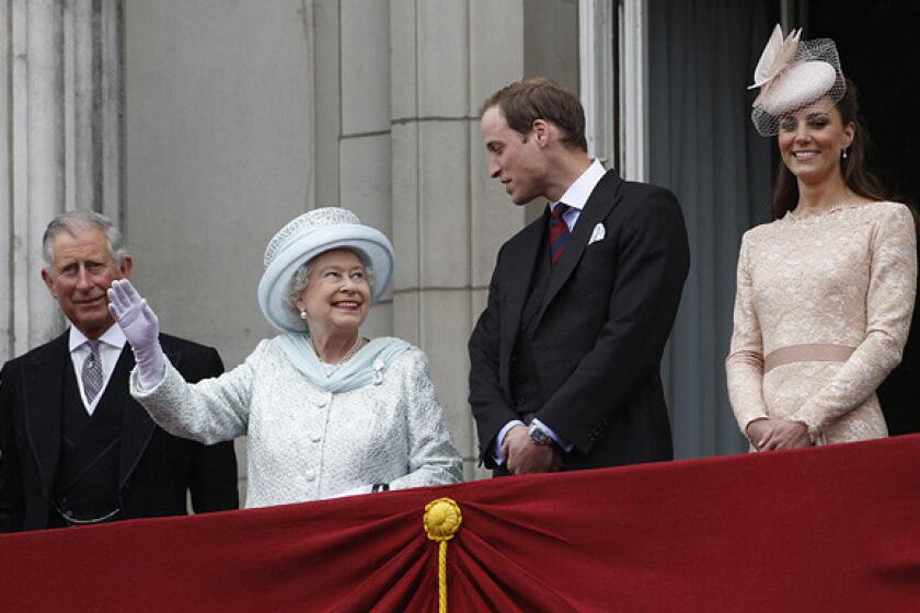 Queen Elizabeth waves from a balcony at Buckingham Palace accompanied by Prince Charles, Prince William and William's wife Kate Middleton, Duchess of Cambridge.