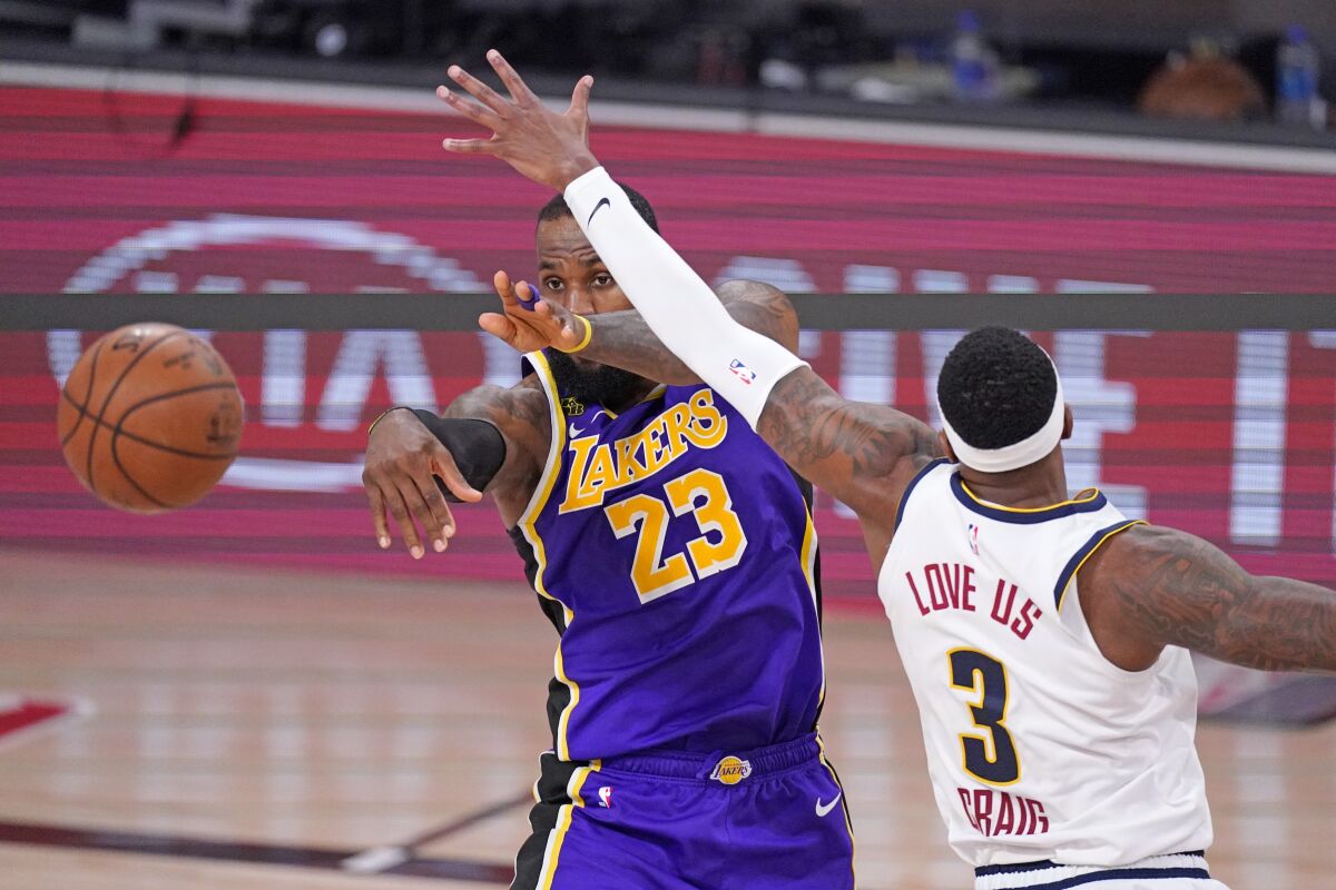 Lakers forward LeBron James makes a pass after driving into the lane against Nuggets forward Torrey Craig during Game 5.