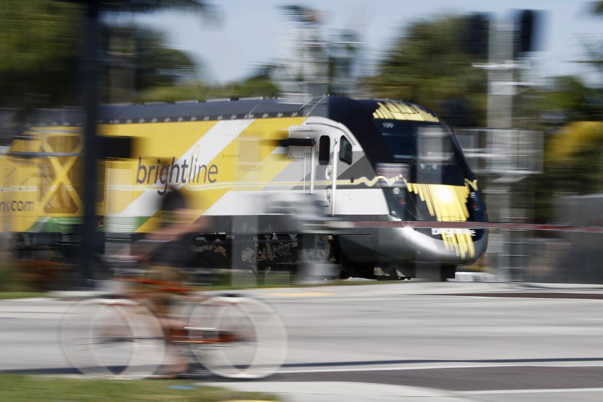 FILE - In this Wednesday, Nov. 27, 2019 file photo, a Brightline passenger train passes by in Oakland Park, Fla. On Tuesday, Aug. 10, 2021, the company said it will resume service sometime in November, 20 months after it closed because of the pandemic. (AP Photo/Brynn Anderson)