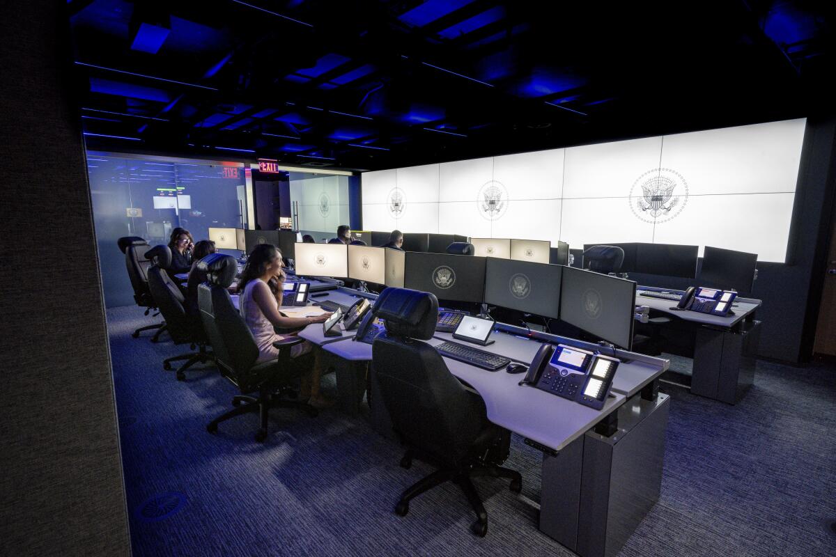 People sit at desks in an operations center.