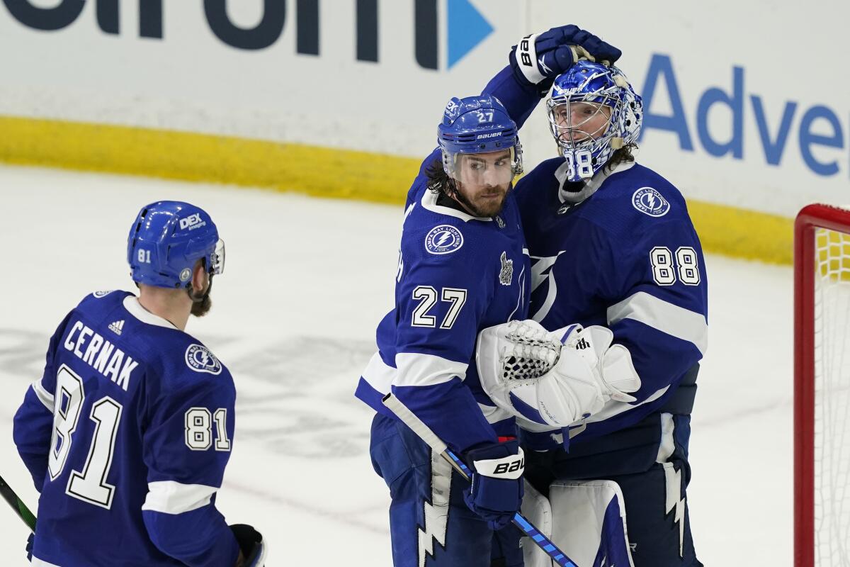 Tampa Bay Lightning defenseman Ryan McDonagh pats goaltender Andrei Vasilevskiy's helmet.