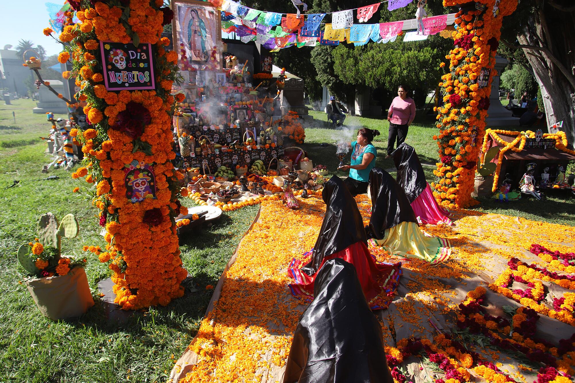 A woman kneels at an altar