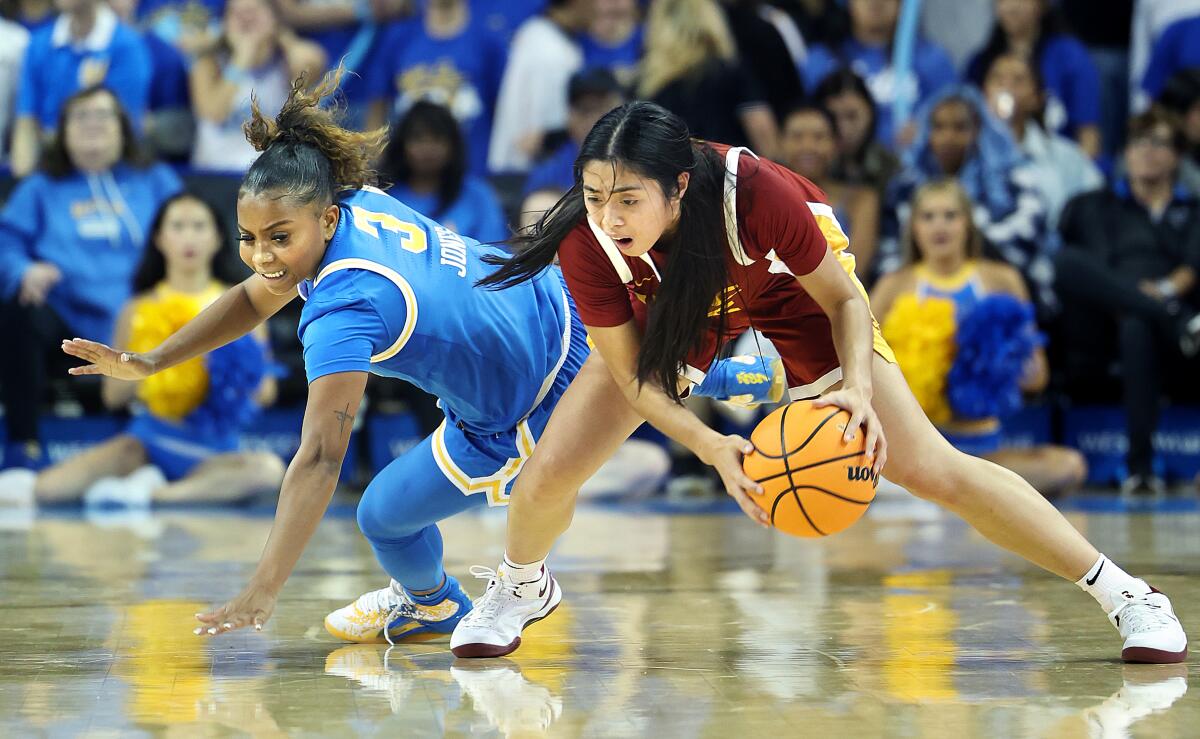 USC'den Kayla Padilla (sağda), Pauley Pavilion'da UCLA'dan Londynn Jones'un önünde topun kontrolünü yeniden kazanıyor.