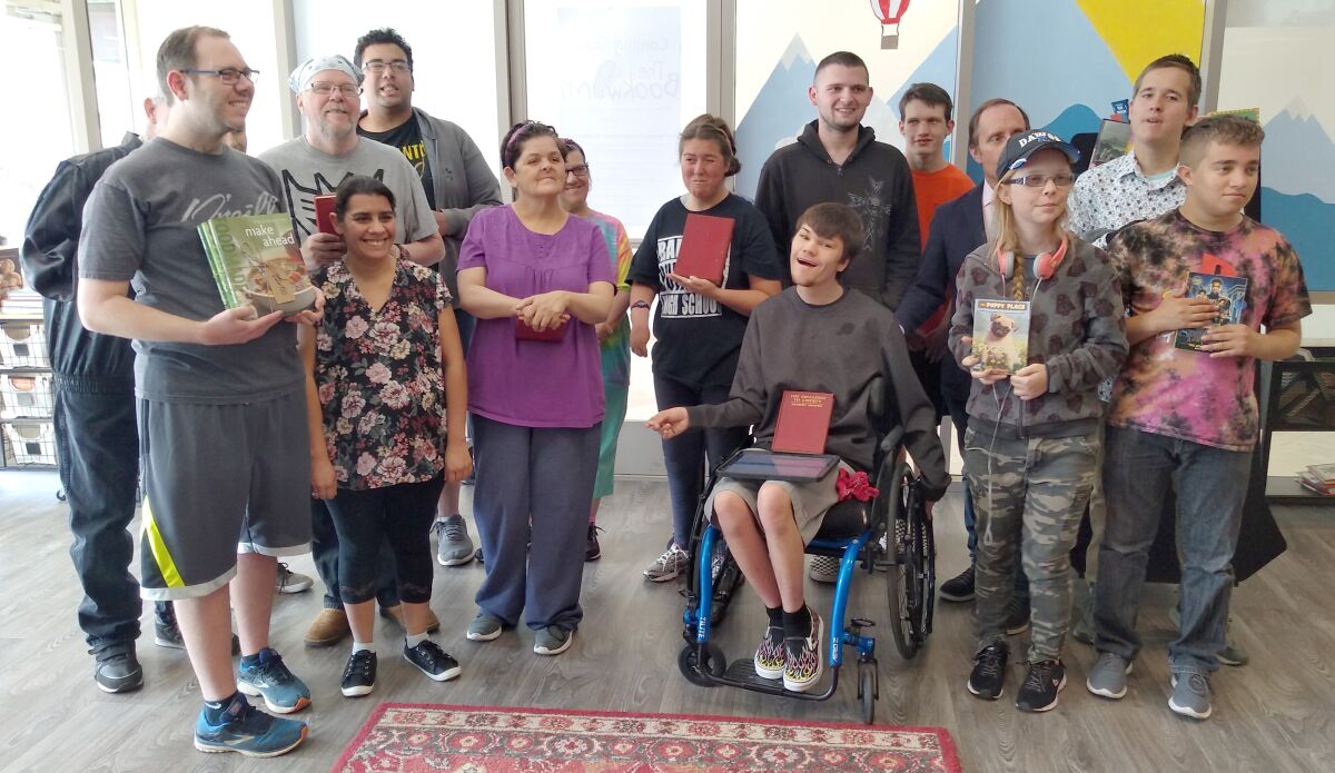 Ramona High School special needs students are the first customers to buy books at the Bookworm Bookstore opening at Generations Day Care.