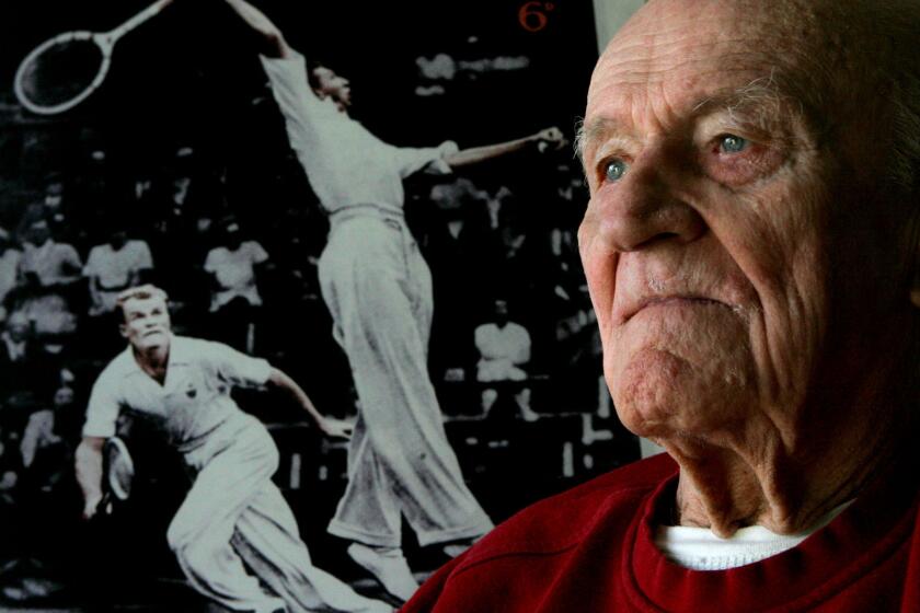 Hall of Fame tennis player Gene Mako is shown in May 2007 at his West Hollywood home in front of a poster featuring himself (at left) and Don Budge at Wimbledon in 1937. Mako died Friday at 97.