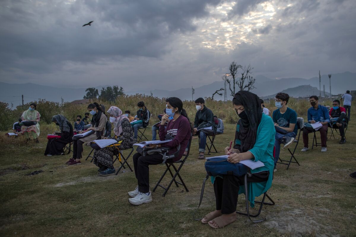 Kashmiri students attend an open-air early morning class inside Eidgah, a ground reserved for Eid prayers, in Srinagar, Indian controlled Kashmir, Friday, July 18, 2020. When months went by without teaching, Muneer Alam, an engineer-turned-math teacher, started the informal community school in the form of an open-air classroom in June. Schools in the disputed region reopened after six months in late February, after a strict lockdown that began in August 2019, when India scrapped the region’s semi-autonomous status. In March schools were shut again because of the coronavirus pandemic. (AP Photo/Dar Yasin)