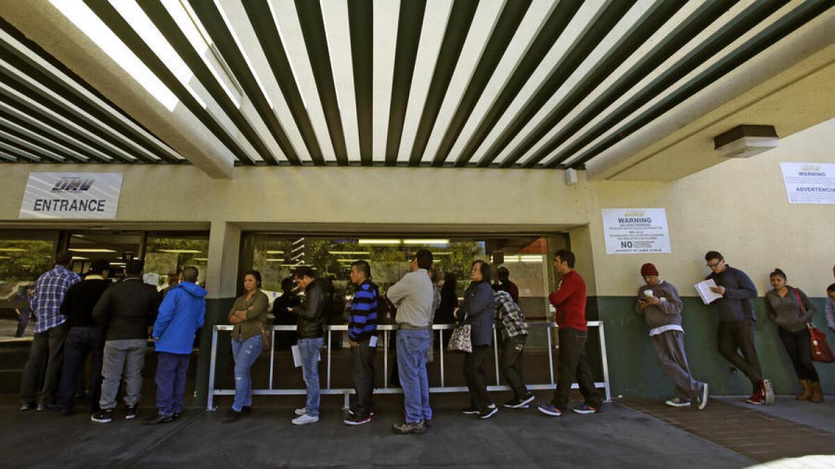 Gente haciendo fila en una oficina del Departamento de Motores y Vehiculos en Los Angeles.