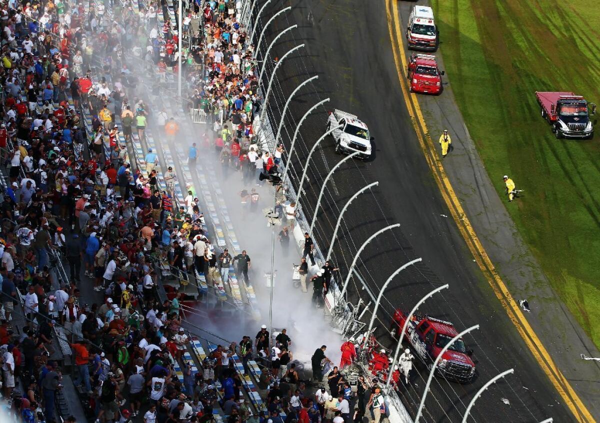 Emergency workers tend to fans injured by flying debris from a crash in a NASCAR Nationwide Series race at Daytona International Speedway on Saturday.